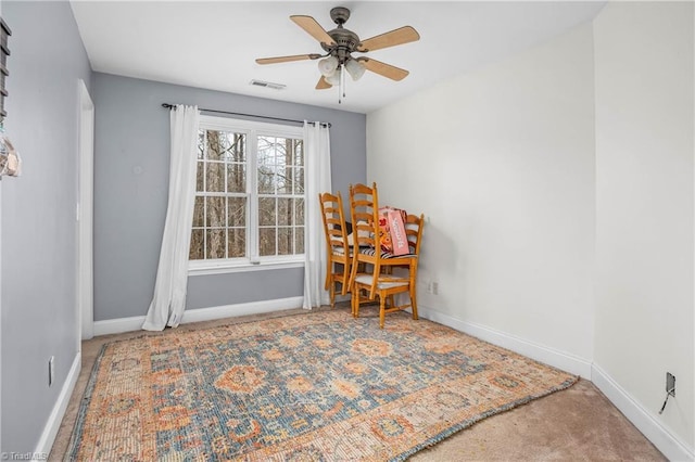 sitting room with ceiling fan and carpet