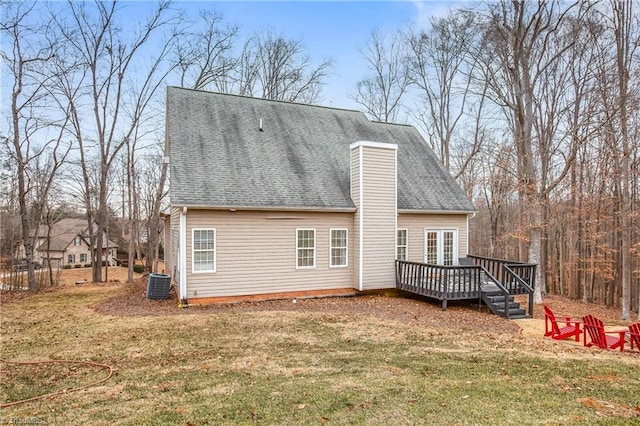 back of house featuring a deck, a lawn, and central AC