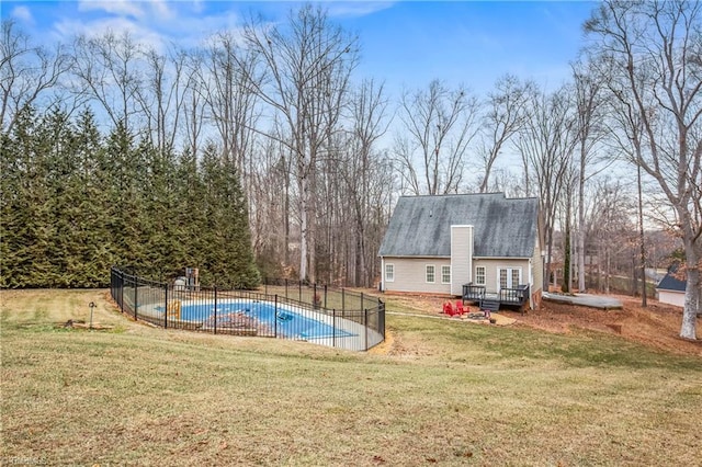 view of swimming pool featuring a deck and a lawn