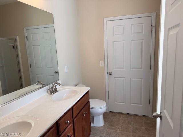 4373 Rex Ct, Winston-Salem, NC 27107 - bathroom featuring double vanity, a shower with shower door, and toilet