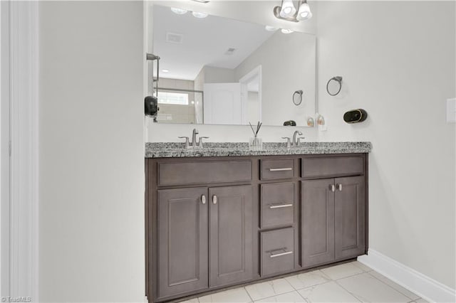 bathroom with tile patterned flooring, a shower with door, and vanity