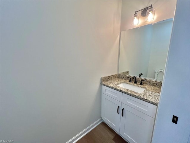 bathroom with vanity, hardwood / wood-style flooring, and toilet