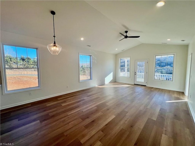 unfurnished living room featuring wood-type flooring, vaulted ceiling, ceiling fan, and a healthy amount of sunlight