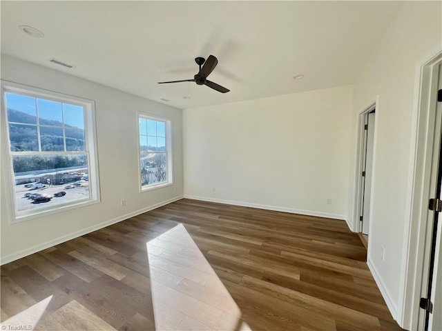 spare room with a mountain view, ceiling fan, and hardwood / wood-style flooring