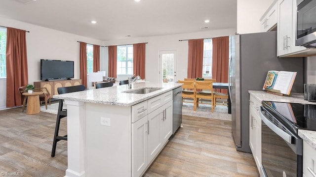 kitchen featuring sink, white cabinets, stainless steel appliances, and light hardwood / wood-style floors