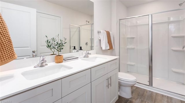 bathroom featuring hardwood / wood-style floors, toilet, an enclosed shower, and vanity