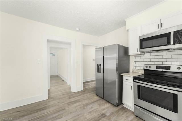 127 Oak Summit Rd, Winston-Salem, NC 27105 - kitchen with stainless steel appliances, white cabinetry, light wood-type flooring, tasteful backsplash, and a textured ceiling