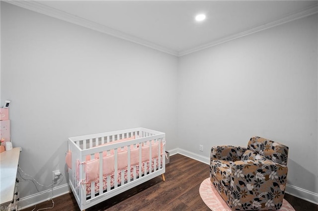 bedroom with dark wood-type flooring, ornamental molding, and a crib