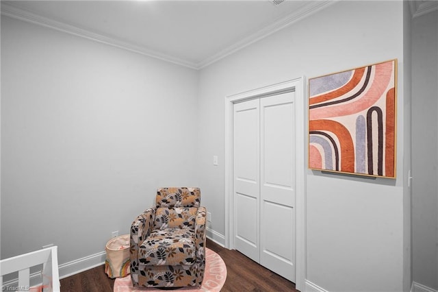 sitting room with dark wood-type flooring and crown molding