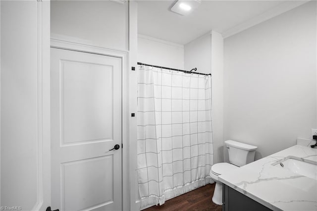 bathroom with wood-type flooring, ornamental molding, vanity, curtained shower, and toilet