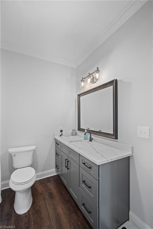 bathroom with toilet, vanity, hardwood / wood-style flooring, and crown molding