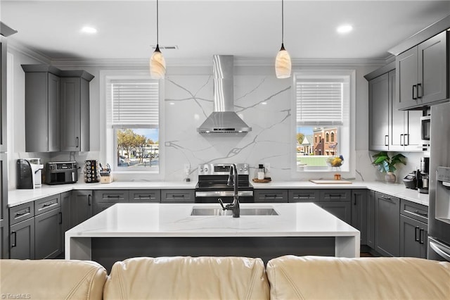 kitchen featuring pendant lighting, a wealth of natural light, and wall chimney exhaust hood