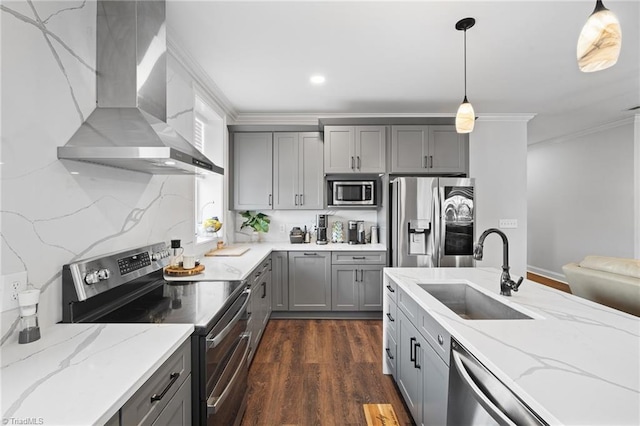 kitchen featuring sink, appliances with stainless steel finishes, dark hardwood / wood-style floors, decorative light fixtures, and wall chimney range hood