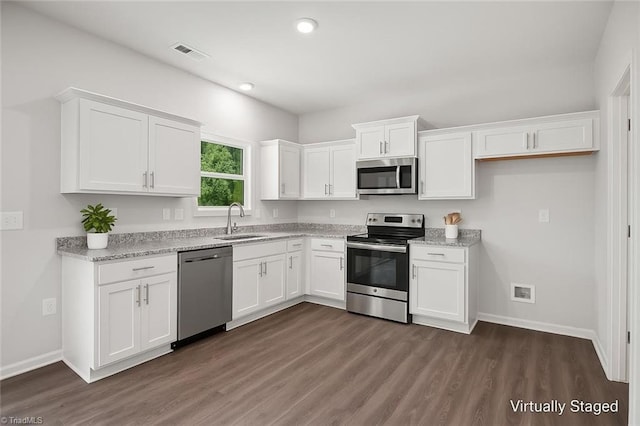 125 Glasmere Ct, Winston-Salem, NC 27101 - kitchen featuring stainless steel appliances, a sink, white cabinets, dark wood-style floors, and baseboards