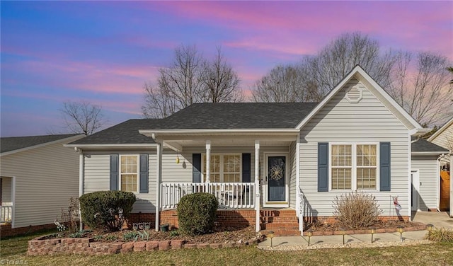 ranch-style home with covered porch and a shingled roof