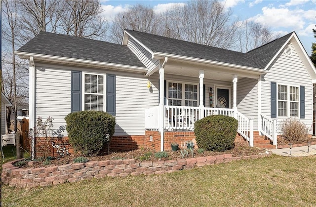 view of front of property with a porch, a shingled roof, and a front yard