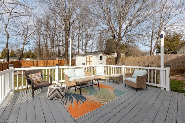 deck featuring an outdoor structure, a fenced backyard, and an outdoor living space