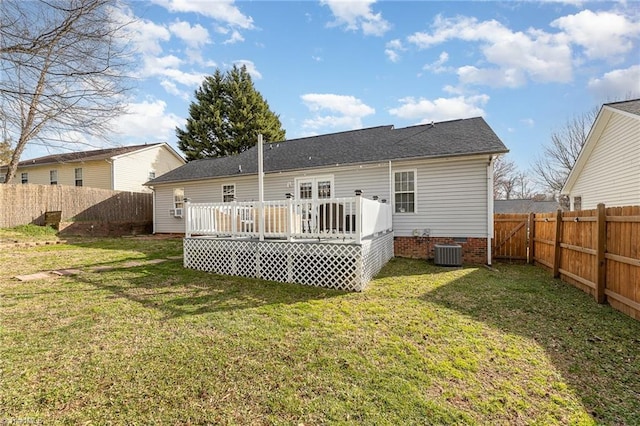 back of property with a deck, a lawn, cooling unit, and a fenced backyard