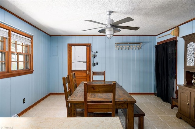 dining room featuring a ceiling fan, baseboards, light tile patterned floors, and a textured ceiling