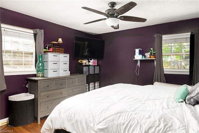 bedroom featuring a textured ceiling, ceiling fan, and wood finished floors