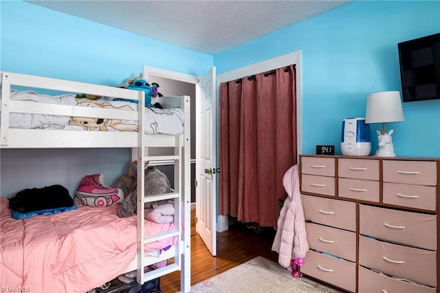 bedroom featuring a textured ceiling and wood finished floors