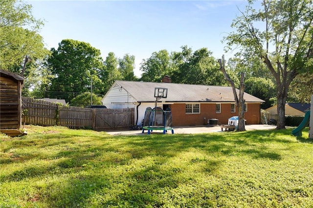 back of house with central AC, a fenced backyard, a gate, a patio area, and a yard