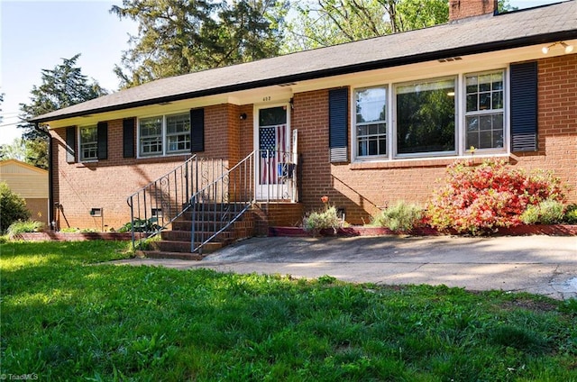 single story home with brick siding, a front lawn, and a chimney