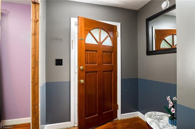 foyer entrance featuring baseboards and wood finished floors