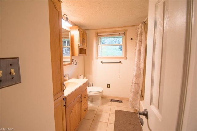 bathroom with vanity, toilet, tile patterned floors, a textured ceiling, and visible vents