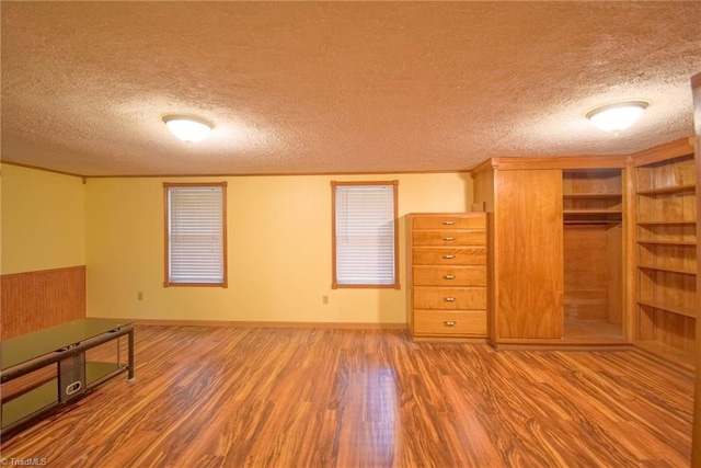 unfurnished bedroom featuring a textured ceiling, wood finished floors, and a closet