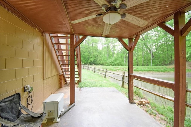 view of patio / terrace with fence, a ceiling fan, and stairway