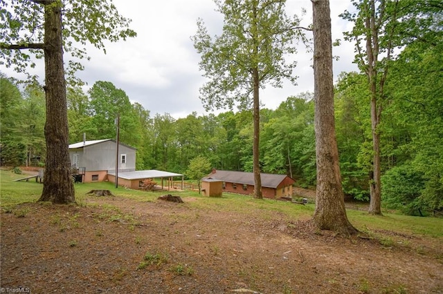 view of yard with a view of trees and dirt driveway