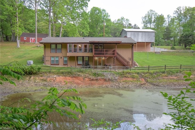 rear view of property featuring a fenced backyard, a yard, and stairway
