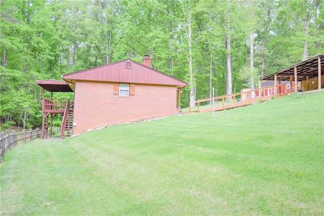 view of yard with fence, a deck, stairway, and a forest view