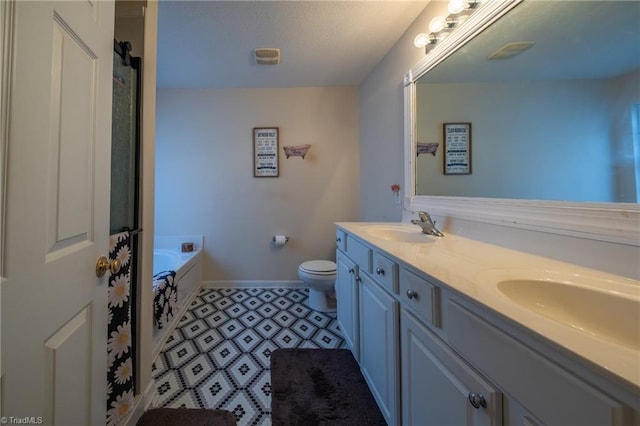 2755 Amesbury Rd, Winston-Salem, NC 27103 - bathroom with double vanity, baseboards, toilet, a bath, and a textured ceiling