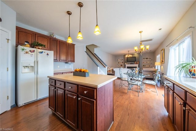 kitchen featuring a center island, hanging light fixtures, white refrigerator with ice dispenser, a notable chandelier, and hardwood / wood-style flooring