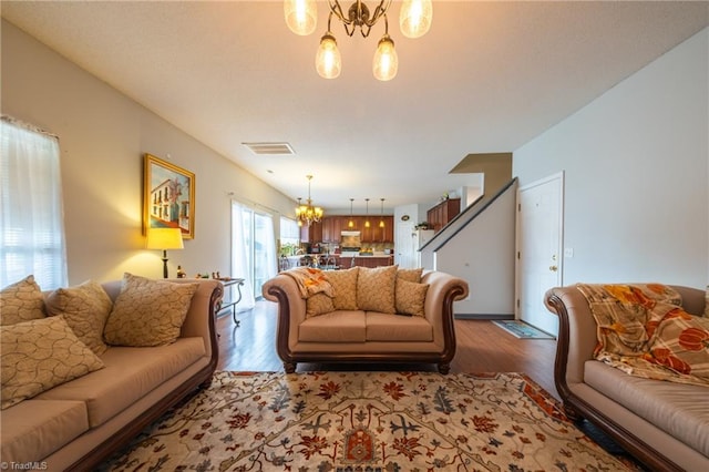 living room with wood-type flooring and a notable chandelier