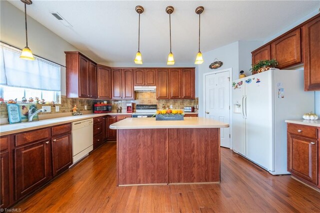 2755 Amesbury Rd, Winston-Salem, NC 27103 - kitchen featuring white appliances, under cabinet range hood, dark wood-style flooring, and light countertops