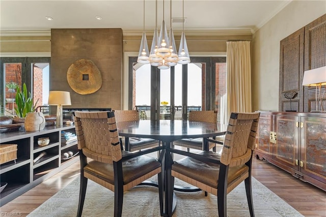 dining room featuring an inviting chandelier, hardwood / wood-style floors, and ornamental molding