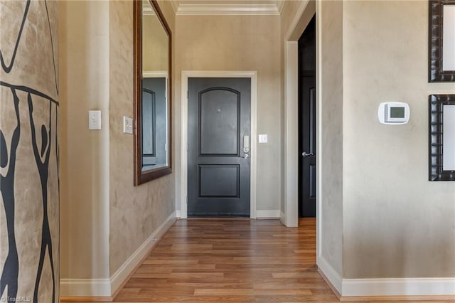 corridor with hardwood / wood-style floors and ornamental molding