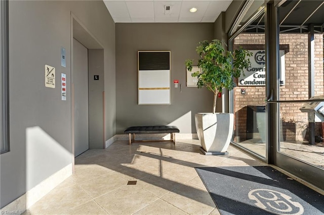 interior space featuring elevator, tile patterned floors, and a healthy amount of sunlight