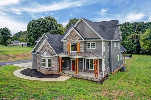 craftsman inspired home with a front lawn, covered porch, and cooling unit