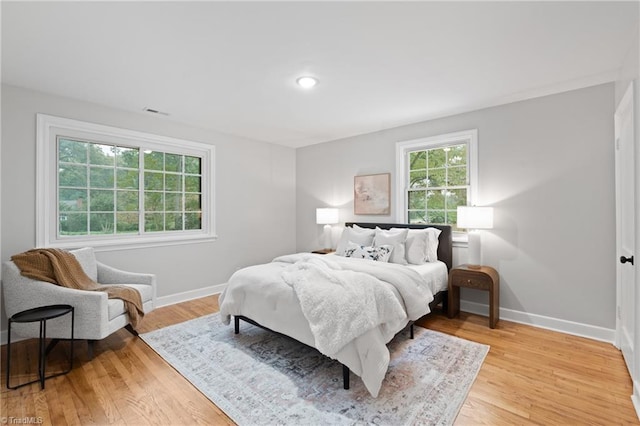 bedroom featuring light wood-style flooring, recessed lighting, baseboards, and visible vents