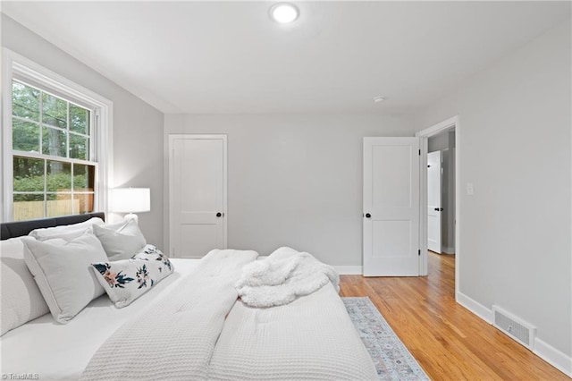 bedroom featuring light wood-style flooring, baseboards, and visible vents