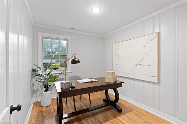 office with crown molding, baseboards, light wood finished floors, visible vents, and a decorative wall
