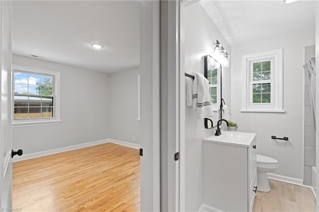 bathroom featuring a shower with shower curtain, hardwood / wood-style floors, vanity, and toilet