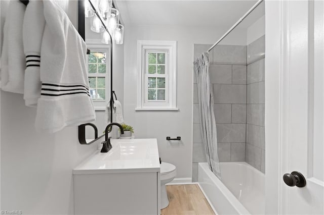 full bathroom featuring toilet, vanity, wood finished floors, baseboards, and shower / bath combination with curtain