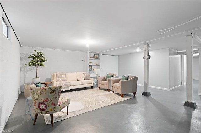 living room with concrete block wall and concrete flooring