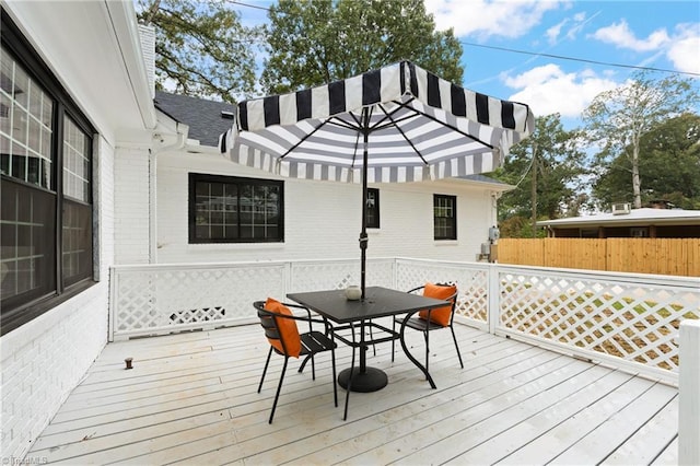 deck with outdoor dining area and fence
