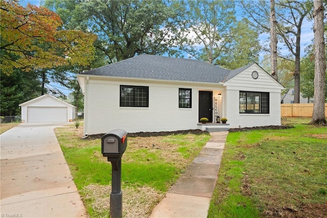 view of front of house featuring fence, a front yard, an outdoor structure, and brick siding